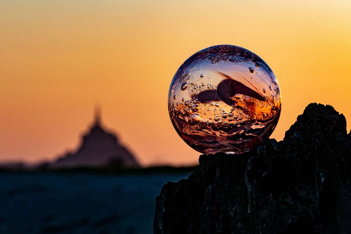 Souffle de verre au Mont Saint Michel Pièce de verre soufflée au couché de soleiln à la pointe du groin, avec en fond le Mont Saint Michel